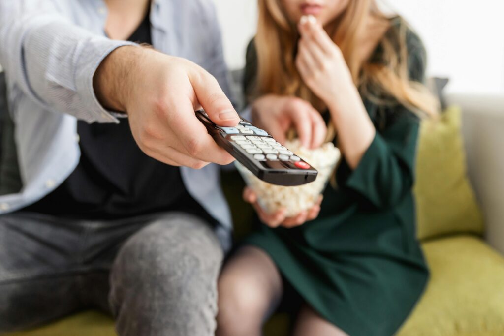 couple deciding what to watch on TV pointing the remote at the screen