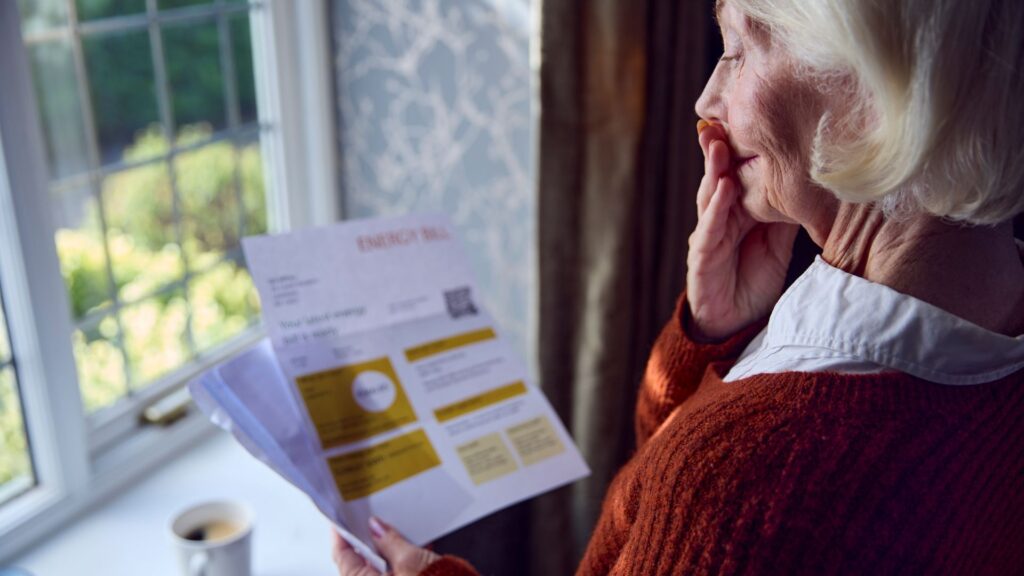 image of pensioner reading energy bill in worry